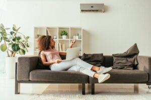 woman at home turning on ac system